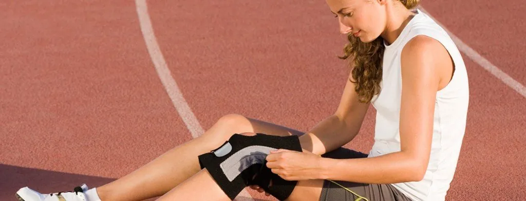 Woman sitting with a support brace on her knee