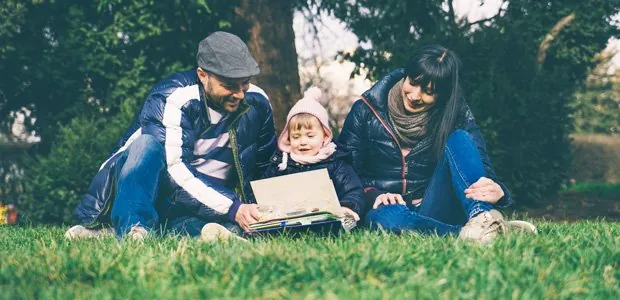 Family reading together outdoors