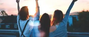 Young women raising their arms outdoors