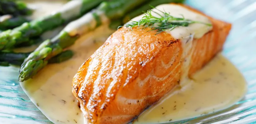 Cooked salmon fillet with sauce and vegetables