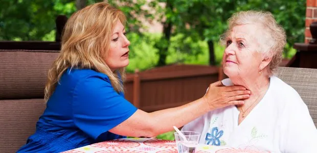 Woman assisting an older person with an exercise