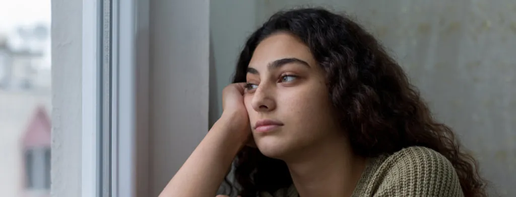 Young woman looking out of a window