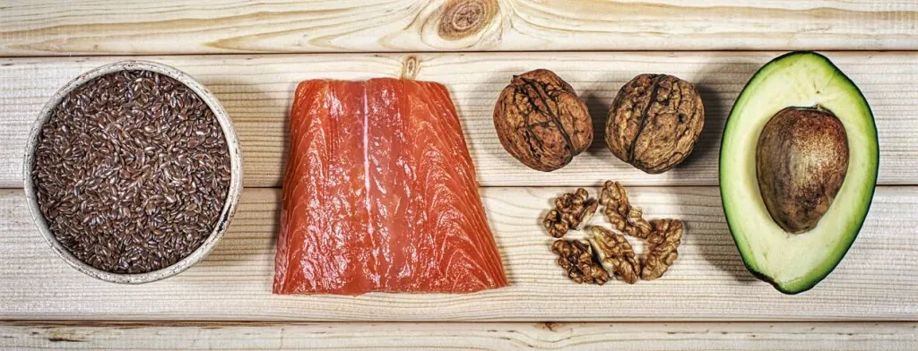 Salmon, avocado, nuts and seeds on a wooden board