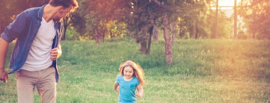 Adult and child running outdoors